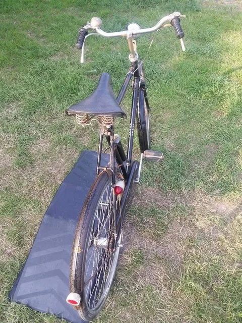 The black Raleigh from behind, with a sprung saddle and red rear reflectors