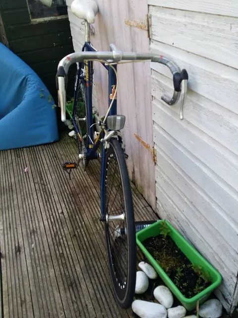 The blue Raleigh from the front, with drop bars and a front reflector