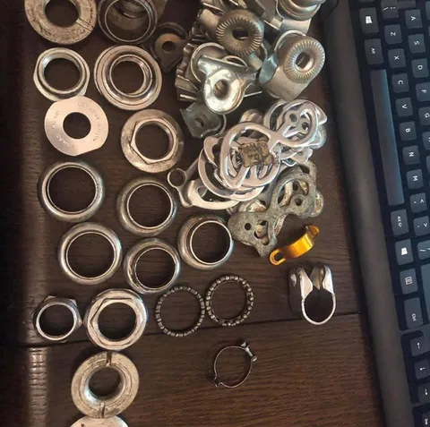 Bearing cups, locknuts, ball cages and clamps laid out on a desk