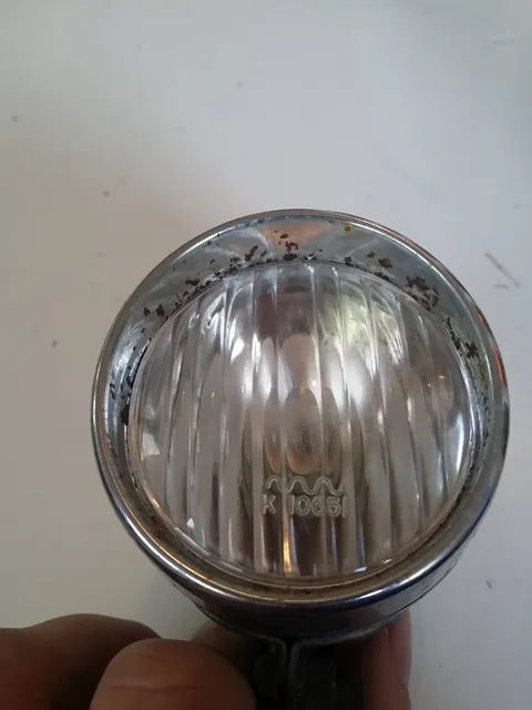 Front lamp glass with rust on the chrome rim