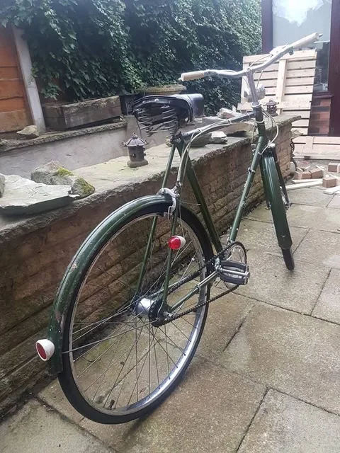 Rear three-quarter view of the green Hercules, with a sprung saddle and red reflectors