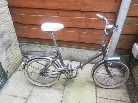 Side view of the brown Hercules folding bike with cream-wall tyres