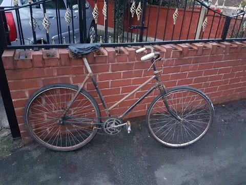 Ladies' bicycle with a sprung saddle against a brick wall