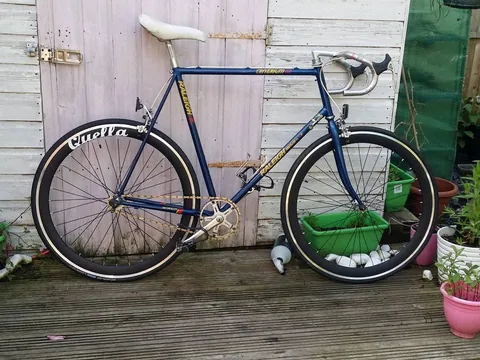 Blue Raleigh road bike with Criterium 12 on the top tube and deep rims marked Quella