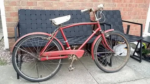 Red bicycle with a white saddle, a long chainguard and red mudguards
