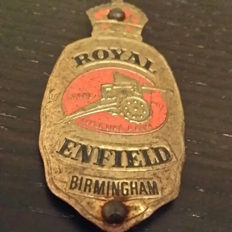 Royal Enfield head badge with a crown and a field gun, marked Birmingham