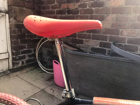 Red plastic saddle on a chrome seat post