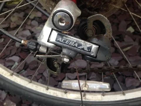Shimano Acera-X rear derailleur on a muddy wheel