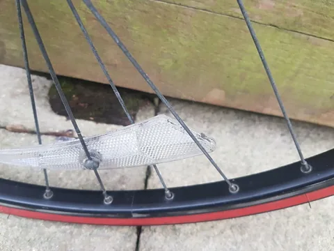 Clear spoke reflector on a black rim wheel
