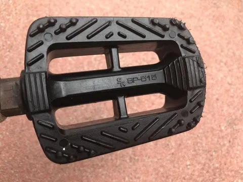 Black plastic pedal marked SR SP-516