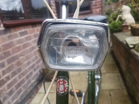 Square chrome headlamp with Sturmey Archer moulded into the lens, above a Hercules head badge