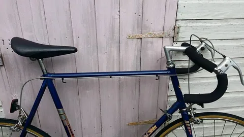Blue top tube with cable guides, below a black saddle