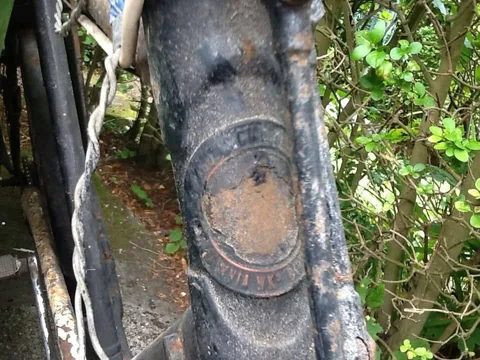 Worn, rusty Hercules head badge marked Britannia Wks on a black frame